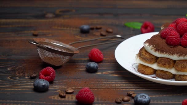 Portion klassisches Tiramisu-Dessert mit Himbeeren und Blaubeeren auf Holzgrund — Stockvideo
