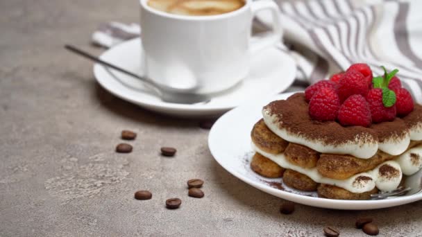 Porción de clásico postre tiramisú con frambuesas y taza de café sobre fondo de hormigón gris — Vídeos de Stock