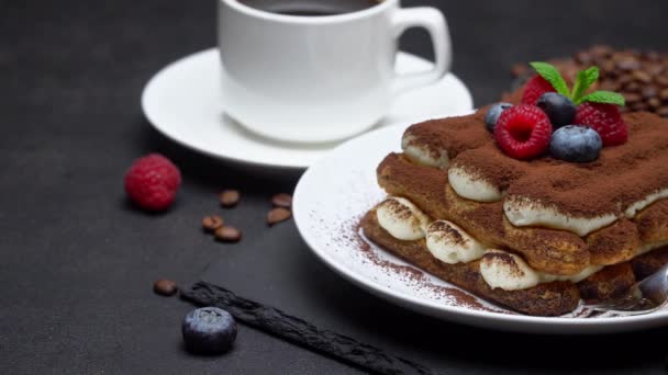 Portion of Classic tiramisu dessert with raspberries and blueberries and coffee concrete background — Stockvideo