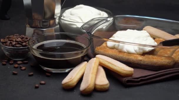 Italian Savoiardi ladyfingers Biscuits and cream in baking dish, coffe maker on concrete background — стокове відео