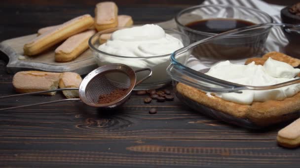 Talian Savoiardi ladyfingers Biscuits and cream in glass baking dish and coffee on wooden background — Wideo stockowe