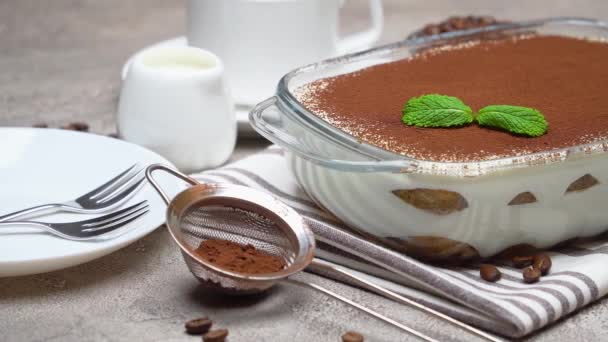 Tiramisu dessert in glass baking dish and cup of fresh hot espresso coffee on concrete background — 图库视频影像