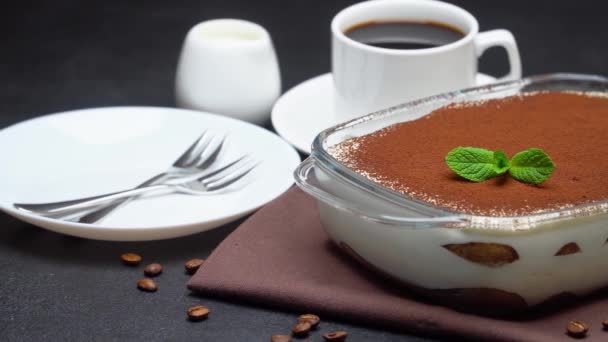 Tiramisu dessert in glass baking dish and cup of espresso coffee on concrete background — Stock Video
