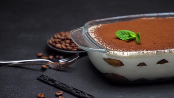 Italian Tiramisu dessert in glass baking dish on stone serving board on concrete background — Stock Video