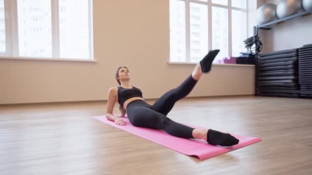 4x slow motion video of Beautiful young woman working out and stretching indoors — Stock Video