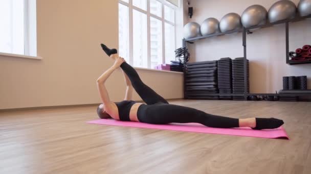 4x slow motion video of Beautiful young woman working out and stretching indoors — Stock Video