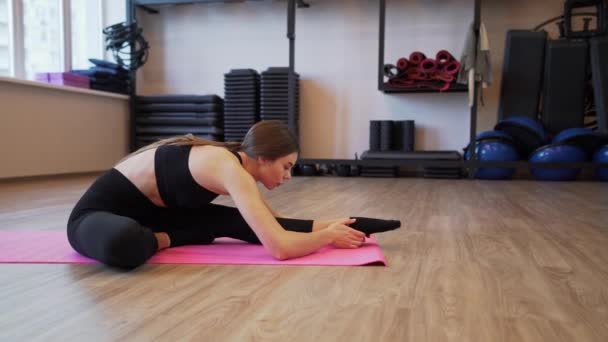 4x slow motion vídeo of Beautiful young woman working out and stretching indoors — Vídeo de Stock