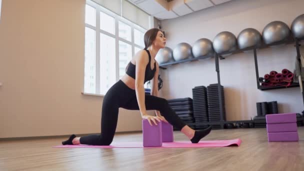 4x slow motion video van mooie jonge vrouw uit te werken en stretching binnen — Stockvideo