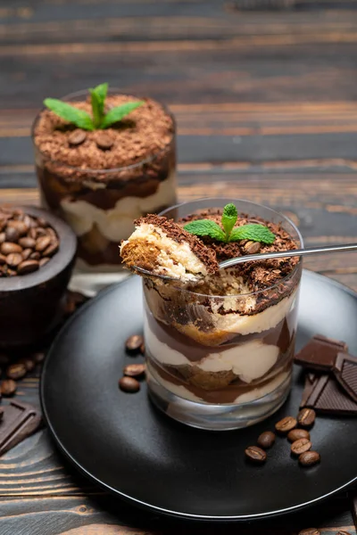 Classic tiramisu dessert in a glass cup on wooden background — Stockfoto