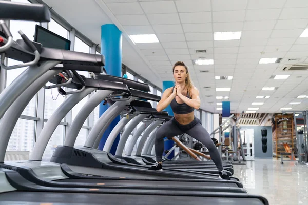 Junge sportliche Frau auf Laufmaschine in Turnhalle — Stockfoto