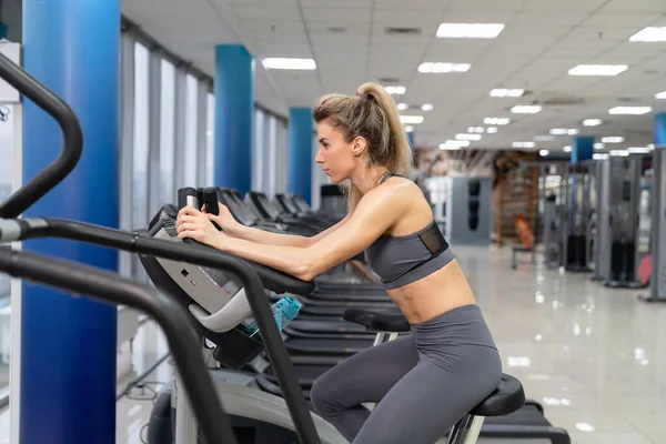 Junge Frau beim Turnen auf dem Fahrrad — Stockfoto