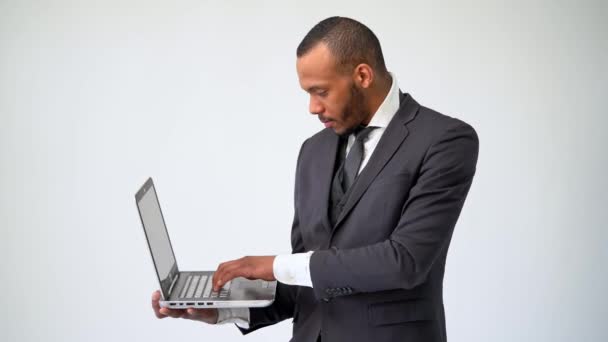 Homem de negócios afro-americano profissional segurando computador portátil — Vídeo de Stock