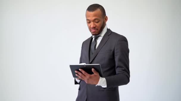 Профессиональный афро-американский бизнесмен держит планшетный компьютер и чашку кофе — стоковое видео