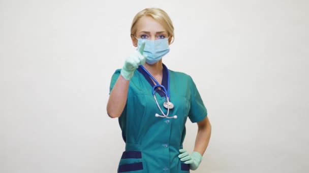 Médico enfermeira mulher usando máscara protetora e luvas de látex aponta um dedo para o espectador — Vídeo de Stock