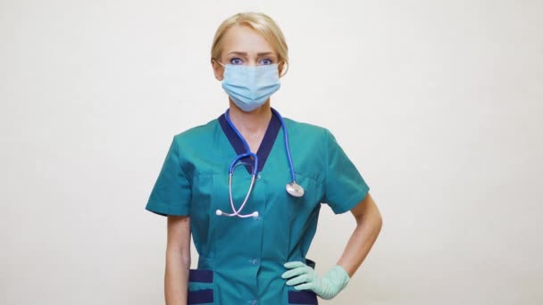 医療看護師の女性は保護マスクとラテックス手袋を身に着けています-下に大きな親指を示す — ストック動画