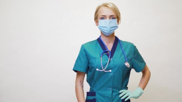 Médico enfermera mujer con máscara protectora y guantes de látex - mostrando en el espacio de copia vacío — Vídeos de Stock
