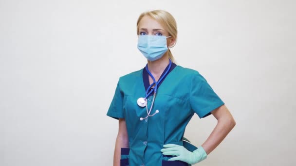 Médecin infirmière femme avec stéthoscope portant un masque protecteur et des gants en caoutchouc ou en latex — Video