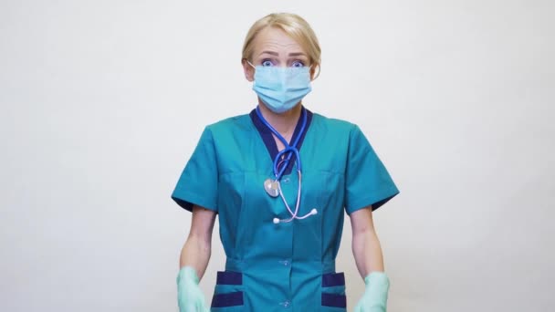 Médico enfermera mujer con máscara protectora y guantes de goma o látex - asustado y estresado — Vídeos de Stock