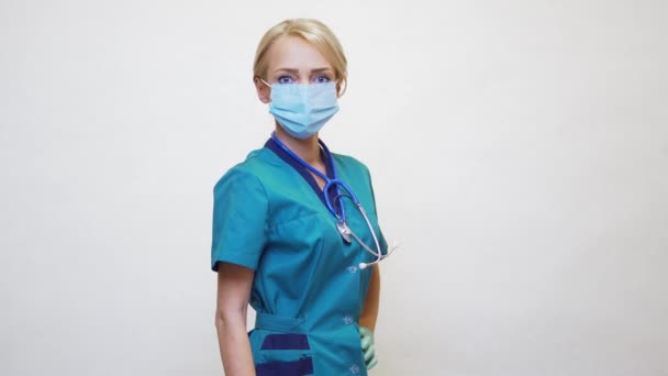 Läkare sjuksköterska kvinna bär skyddsmask och latexhandskar - visar stor tumme upp — Stockvideo