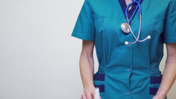 보호용 마스크를 착용하고 있는 의사의 간호사 - 사죄하는 기도나 젤 병을 들고 있는 병 — 비디오