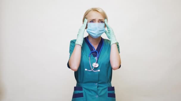 मेडिकल डॉक्टर नर्स महिला सुरक्षात्मक मास्क और रबड़ या लेटेक्स दस्ताने पहनती है सिरदर्द और तनाव — स्टॉक वीडियो