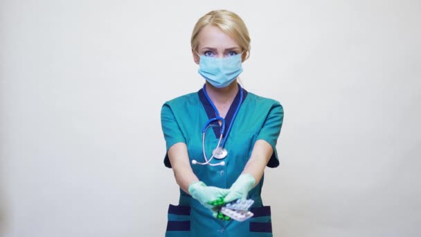 Medical doctor nurse woman wearing protective mask and rubber or latex gloves - holding pills — Stock Video