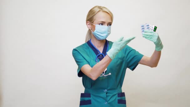 Lékařský lékař zdravotní sestra žena nosí ochrannou masku a gumu nebo latexové rukavice - držení pilulky — Stock video