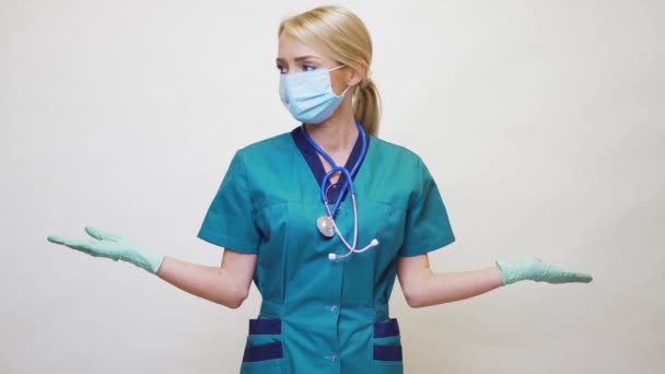 แพทย์หญิงพยาบาลสวมหน้ากากป้องกันและถุงมือลาเท็กซ์ แสดงที่พื้นที่สําเนาที่ว่างเปล่า — วีดีโอสต็อก
