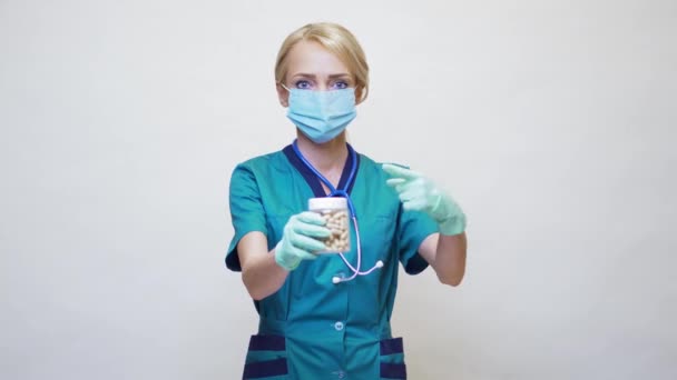 Medical doctor nurse woman wearing protective mask and rubber or latex gloves - holding pills — Stock Video