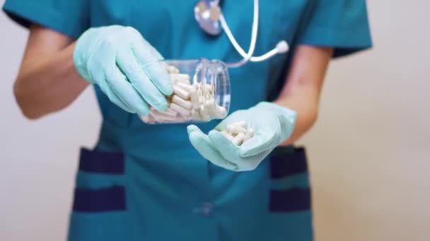 Medico infermiere donna indossando maschera protettiva e guanti di gomma o lattice - tenendo pillole — Video Stock