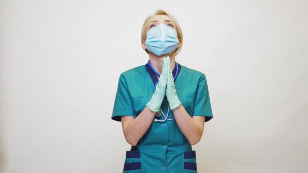 Γιατρός νοσοκόμα γυναίκα φορώντας προστατευτική μάσκα και γάντια λάτεξ - προσεύχεται nad ελπίζοντας χειρονομία — Αρχείο Βίντεο