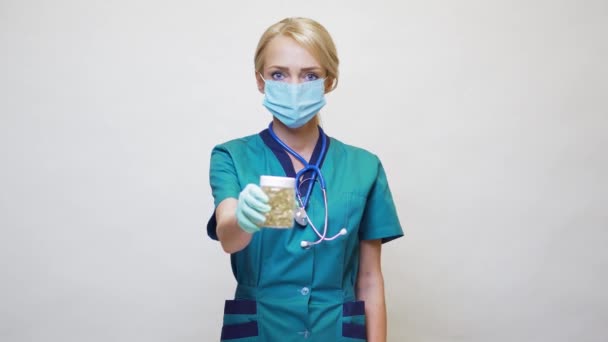 Lékařský lékař zdravotní sestra žena nosí ochrannou masku a gumu nebo latexové rukavice - držení pilulky — Stock video