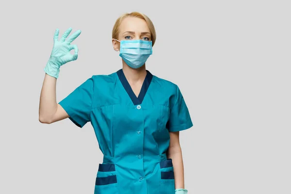 Γιατρός νοσοκόμα γυναίκα φορώντας προστατευτική μάσκα και γάντια λατέξ - που δείχνει OK σημάδι — Φωτογραφία Αρχείου