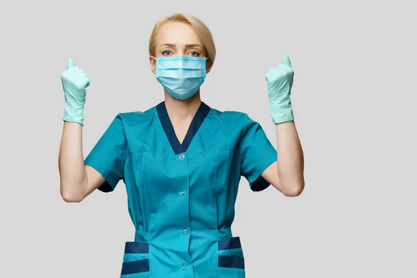 Medical doctor nurse woman wearing protective mask and rubber or latex gloves - yes win gesture — Stock Photo, Image