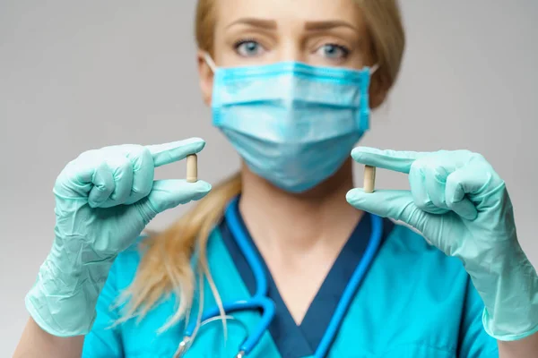 Medische arts verpleegkundige vrouw dragen beschermende masker en rubber of latex handschoenen - Holding pillen — Stockfoto