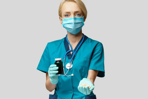 Koruyucu Maske ve Lastik Eldiven Giyen Doktor Hemşire Kadın veya Lateks Eldiven Tutma Hapları — Stok fotoğraf
