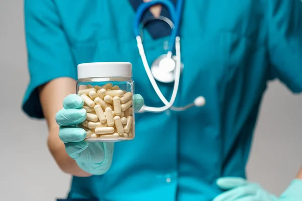 Ärztin Krankenschwester mit Schutzmaske und Gummi- oder Latexhandschuhen - Tabletten halten — Stockfoto