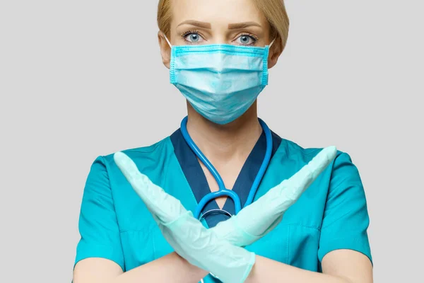Médico enfermera mujer con máscara protectora y guantes de goma o látex - señal de stop gesto — Foto de Stock