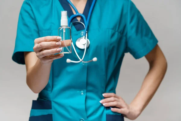 Medical doctor nurse wearing protective mask - holding bottle of sanitizing spray or gel — Stock Photo, Image