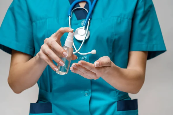 Lékařský lékař zdravotní sestra nosí ochrannou masku - držení láhev sanitační sprej nebo gel — Stock fotografie