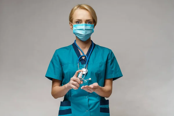 Enfermera médica que usa mascarilla protectora - sosteniendo una botella de aerosol o gel desinfectante —  Fotos de Stock