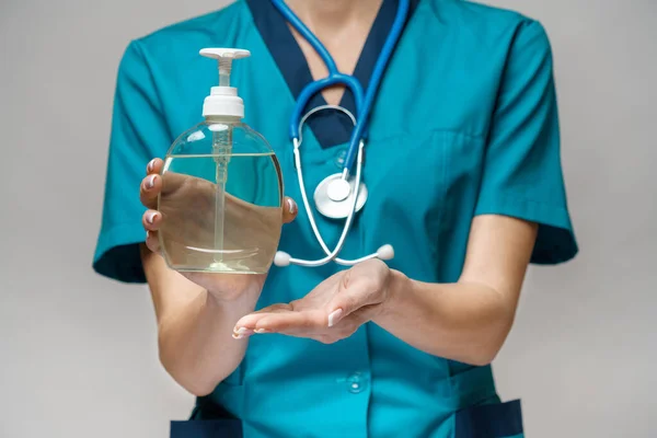 Medical doctor nurse wearing protective mask - holding sanitizing spray or gel or liquid soap — Stock Photo, Image