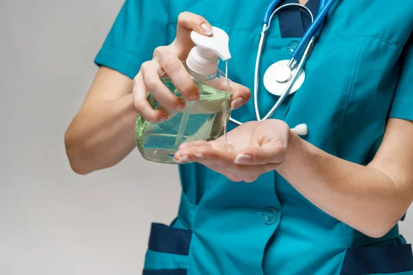 Lékařský lékař zdravotní sestra nosí ochrannou masku - držení sanitační sprej nebo gel nebo tekuté mýdlo — Stock fotografie