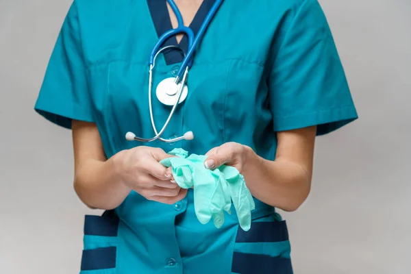 Médico enfermeira mulher com estetoscópio usando máscara protetora e luvas de borracha ou látex — Fotografia de Stock