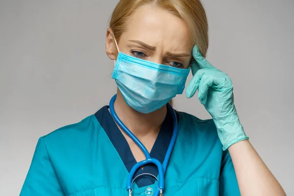 Médico enfermera mujer con máscara protectora y guantes de goma o látex - dolor de cabeza y estrés —  Fotos de Stock