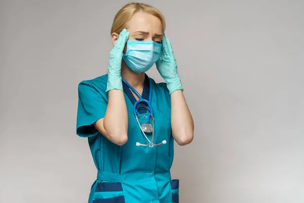 Médico enfermera mujer con máscara protectora y guantes de goma o látex - dolor de cabeza y estrés —  Fotos de Stock