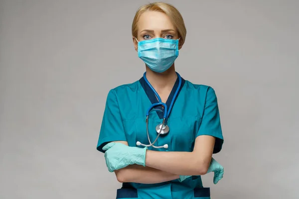 Médico enfermera mujer con estetoscopio con máscara protectora y guantes de goma o látex — Foto de Stock