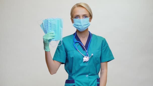 Médico enfermera mujer con estetoscopio sobre fondo gris claro - mostrando máscara protectora — Vídeo de stock