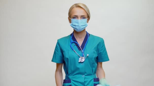Врач медсестра женщина со стетоскопом - показывая защитную маску и дезинфицирующее средство — стоковое видео