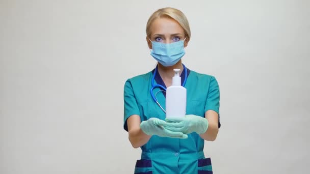 Medische arts verpleegkundige dragen beschermende masker - Holding Sanitizing Spray of gel of vloeibare zeep — Stockvideo